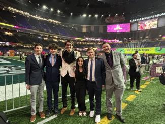 A group photo of college students on an NFL field